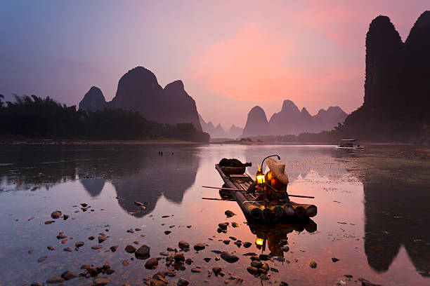 White Beard Cormorant fisherman getting ready for night fishing on the Li River, near Xingping Town, Guangxi province, China. lantern photos stock pictures, royalty-free photos & images