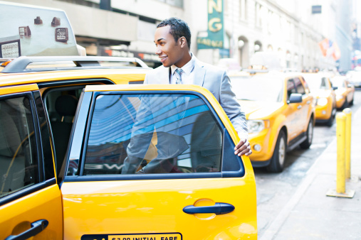 Businessman taking a Taxi in New York city - Taxi banner is my own copyright -Soft focus and added some grain.