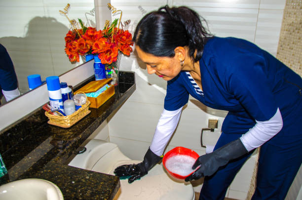 Housemaid cleaning the bathroom stock photo