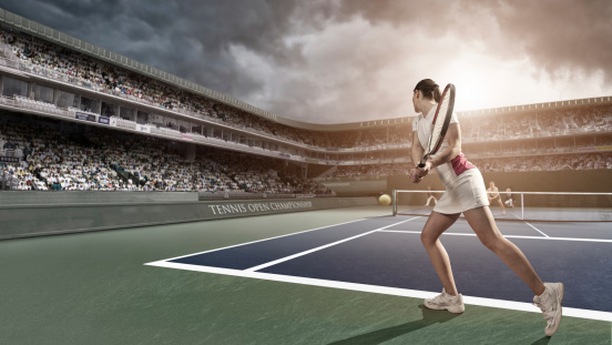 professional female tennis player about to hit a backhand return during a tournament match in stadium under cloudy sky at sunset
