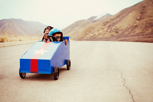 Cruisin' A three year old boy and his chimpanzee take to the street in their box car. 3 monkeys stock pictures, royalty-free photos & images