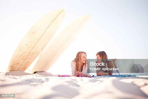 Zwei Teenager Surfer Mädchen Lachen Und Gossiping Am Strand Stockfoto und mehr Bilder von Afrika