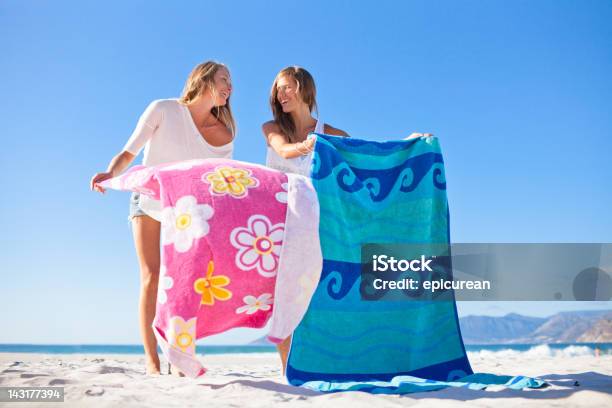 Two Attractive Teenage Girls Relaxing And Gossiping On The Beach Stock Photo - Download Image Now