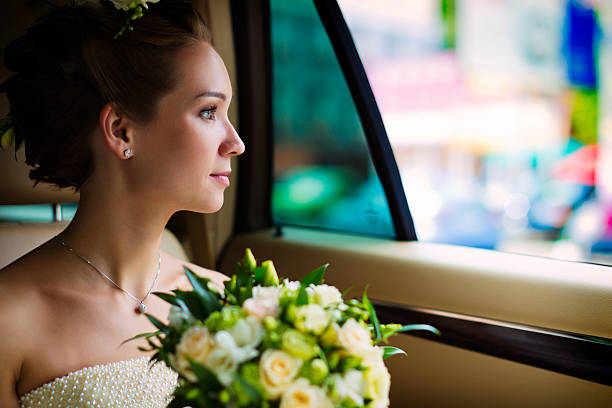 Young bride sitting in the car stock photo
