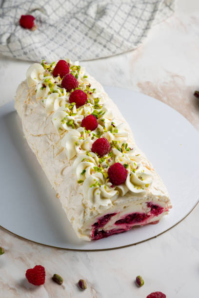 istock meringue roll with raspberries and pistachios on white marble table vertical 1431775155