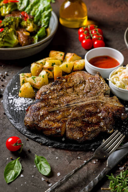 istock t-bone steak on the bone on dark stone plate with potatoes and tomato sauce on dark table vertical 1431775317