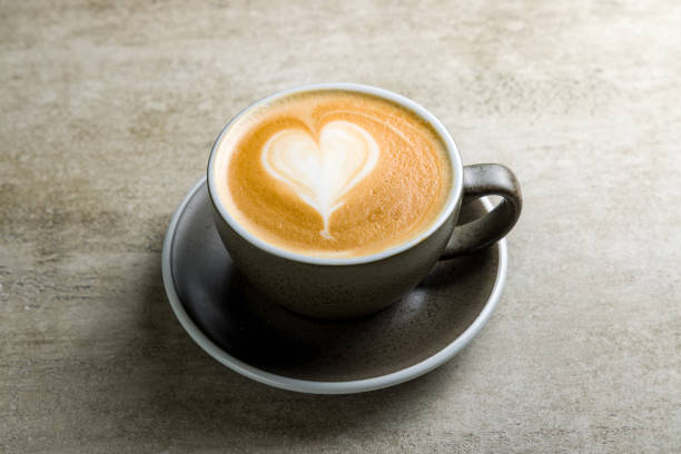istock Cappuccino coffee with heart drawing on grey table 1431775472