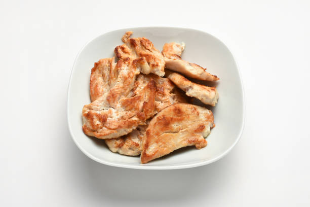 Chicken grill on lettuce on leaves on black plate on white background. High quality photo