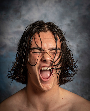 Young man after surfing yells with joy at his achievements.