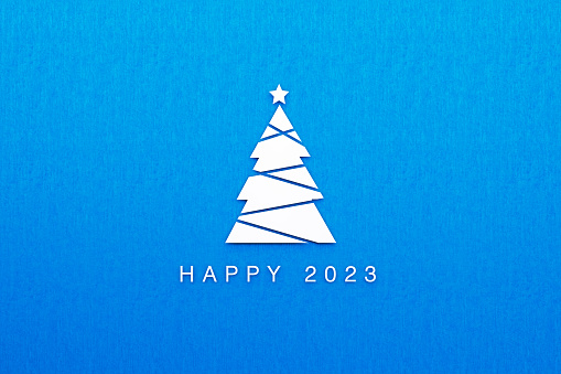Christmas tree and Happy 2023 message on blue background. Horizontal composition with  copy space. Happy 2023 new year concept.