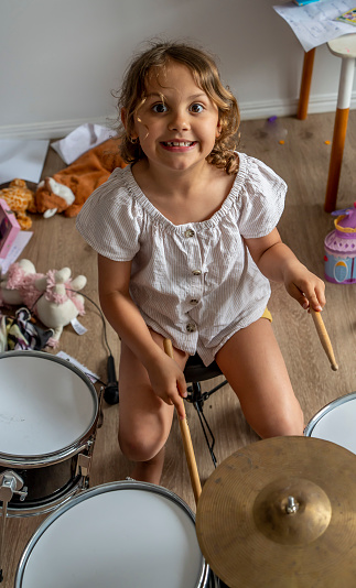 Young girl plays her drums.