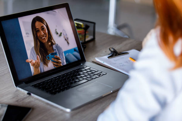 istock Young woman video chatting with a friend while working at the office 1431799888