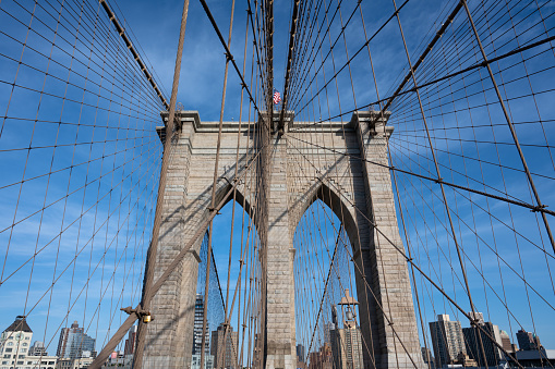 Brooklyn Bridge suspension tower and cables, with the Brooklyn skyline as a backdrop.