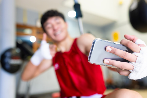 Boxer using his phone after training