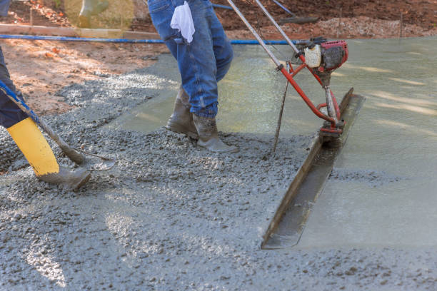 istock Using a machine, the compacted layer of fresh concrete is aligned on the new driveway construction. 1431838305