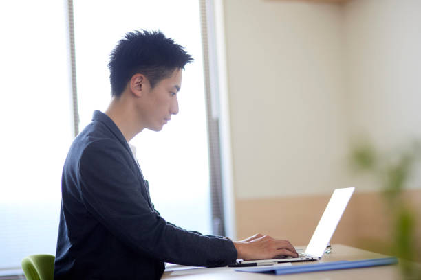 istock Young Japanese businessman operating a personal computer 1431838535