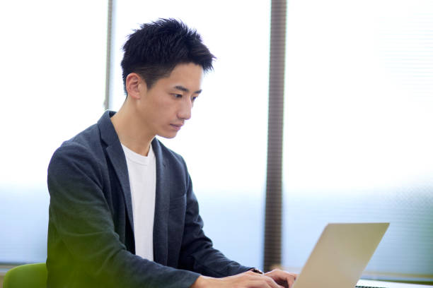istock Young Japanese businessman operating a personal computer 1431838537