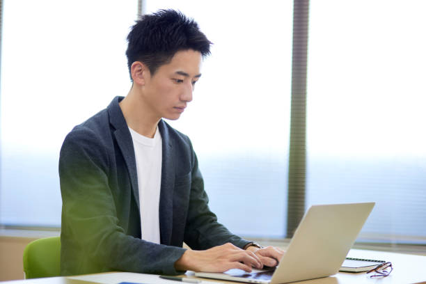 istock Young Japanese businessman operating a personal computer 1431838541