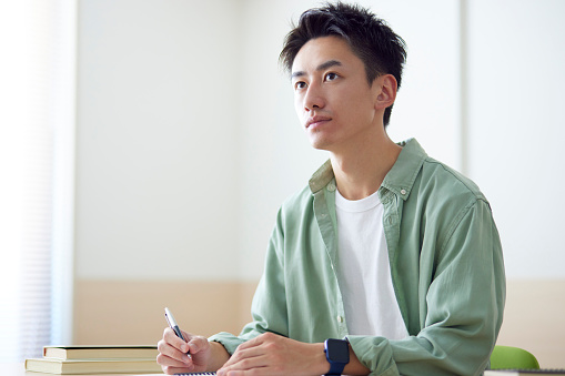 Joven estudiante japonés que estudia en el aula photo