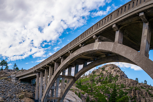 Donner Summit Bridge, aka Rainbow Bridge over Donner Pass on historic US Route 40 near Lake Tahoe, with dramatic clouds, in Truckee, Nevada County, Northern California