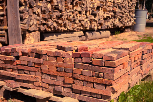 istock Red brick packed in stack are stored on ground outdoors at a hardware store warehouse. Building bricks on pallet on an outdoor warehouse 1431843450