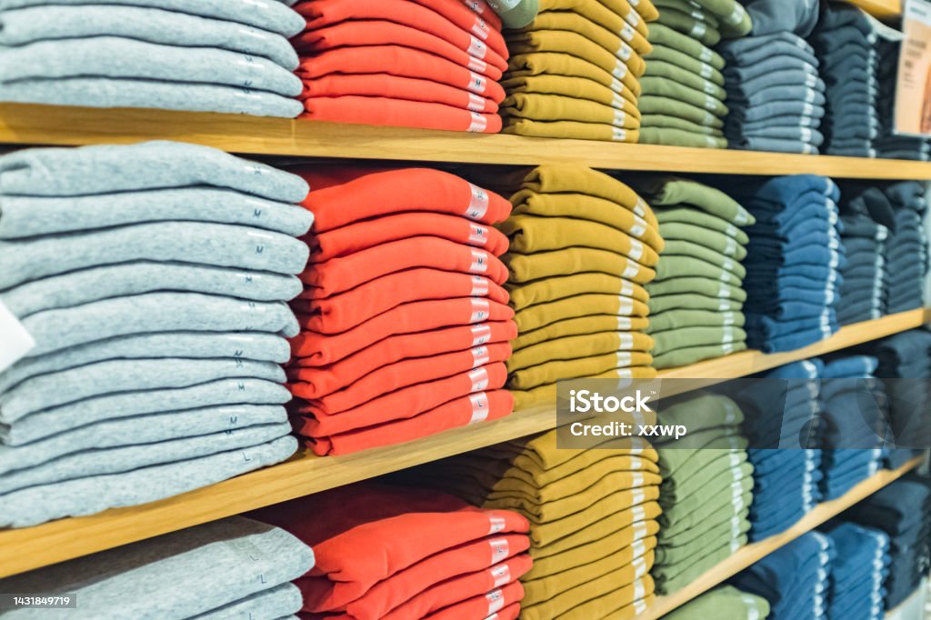 Plenty of sweatshirts in different colors on the shelf Store Stock Photo