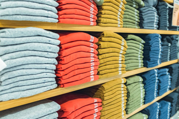 Plenty of sweatshirts in different colors on the shelf Plenty of sweatshirts in different colors on the shelf garment store fashion rack stock pictures, royalty-free photos & images