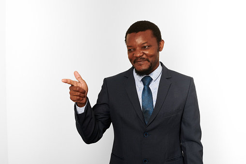 Smiling african american black man in business suit pointing finger gesture isolated on white background. Happy black businessman, chief executive officer approves good deal