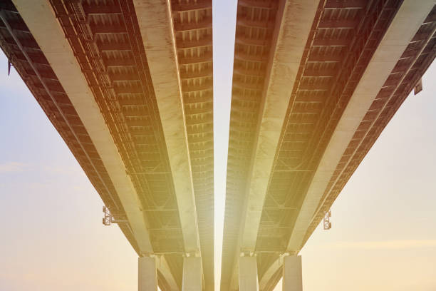 Concrete bridge bottom view in Rostov on Don city over river Don, beautiful sunlight through Voroshilovsky bridge on concrete supports. View under double bridge, monumental architecture building