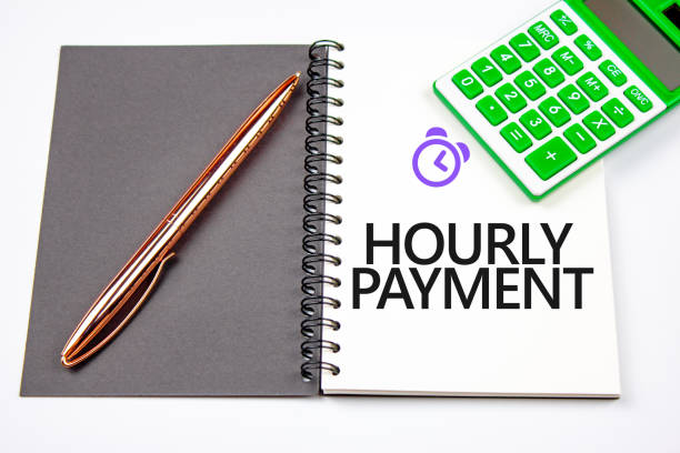 istock Hourly pay concept. Words hourly pay next to alarm clock symbol and calculator. 1431862006
