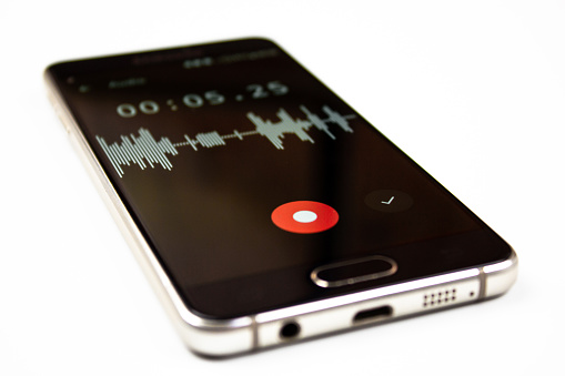 The voice recorder on a smartphone. Voice recording wave on the screen of a smartphone. Recording sounds on a smartphone. Voice recorder noise level wave.