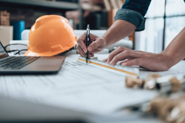 istock Engineering working with drawings inspection and writing on the office desk and Calculator, triangle ruler, safety glasses, compass, vernier caliper on Blueprint. Engineer, Architect, Industry and factory concept. 1431873585