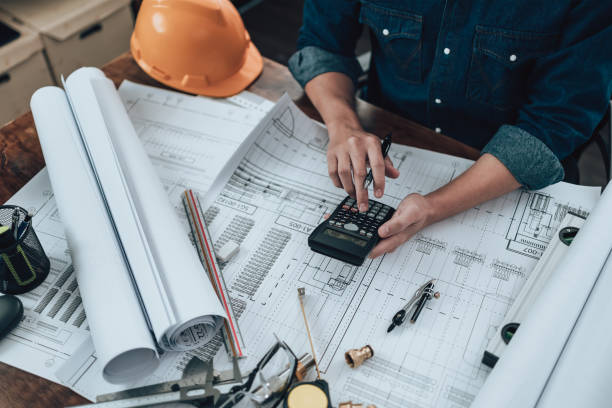 istock Engineering working with drawings inspection and press calculator on the office desk and triangle ruler, safety glasses, compass, vernier caliper on Blueprint. Engineer, Architect, Industry and factory concept. 1431873720