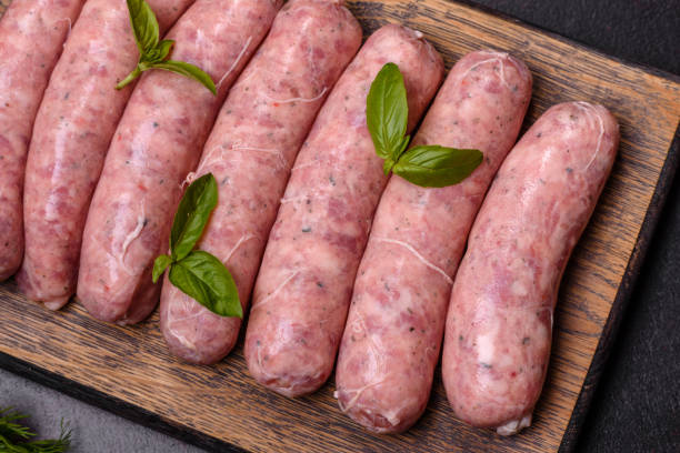 istock Raw sausages with ingredients on a cutting board on a dark concrete background with copy space 1431875069