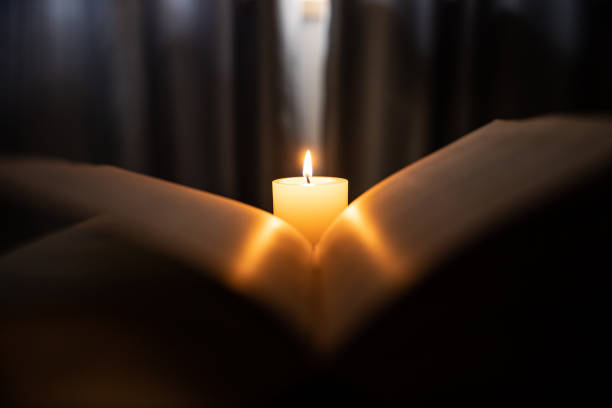 la luce delle candele attraverso il libro antico - eastern religion foto e immagini stock