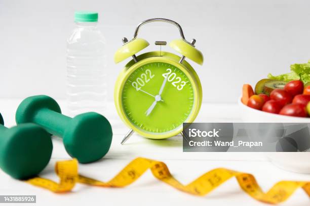 2022 And 2023 On Alarm Clock With Workout Planing For Dieting Sport Exercise Equipment Workout And gym Nutrition Fresh Salad For Fitness Merry Christmas And Happy New Year Concept Stock Photo - Download Image Now