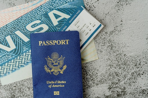 A close up shot of an anonymous person holding his passport, ticket and other documents necessary for going abroad.