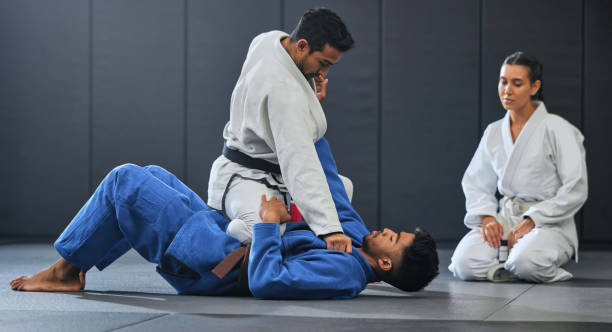Karate student exercise, learning and training with mma coach teaching, sports and workout at gym. Wellness, sport and fitness athlete full mount take down in event, competition or dojo studio.