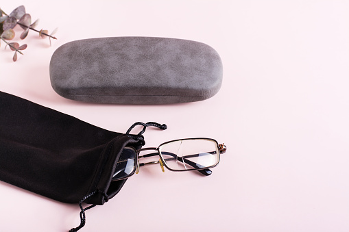 Broken glasses in a soft fabric case and a hard case next to it. The concept of careful storage of optics