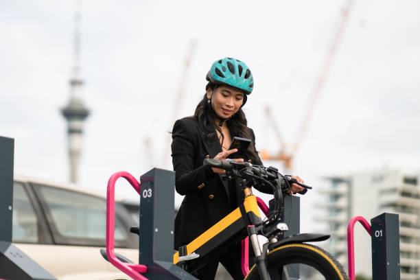 istock Woman recharging e-bike at charging station, using smart phone. 1431903801