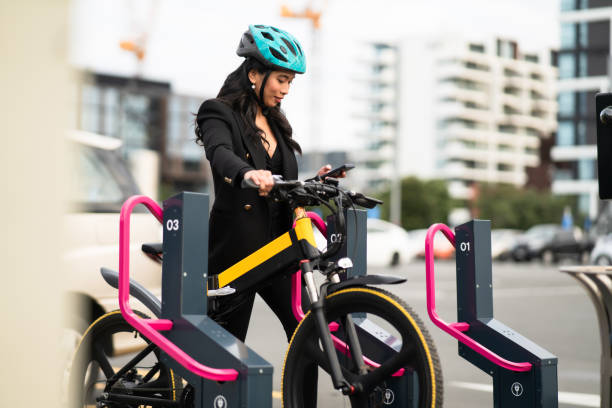 mulher alugando uma e-bike. - bikeshare - fotografias e filmes do acervo