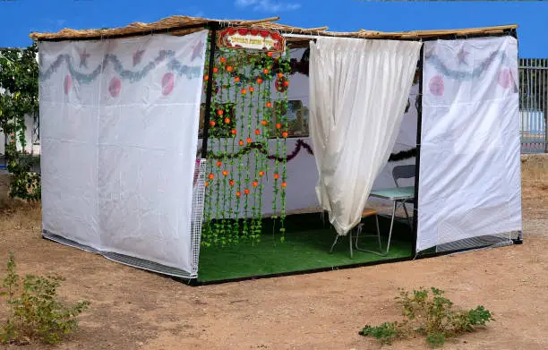 A sukkah or succah is a temporary hut constructed for use during the week-long Jewish festival of Sukkot. It is topped with branches and often well decorated with autumnal, harvest or Judaic themes