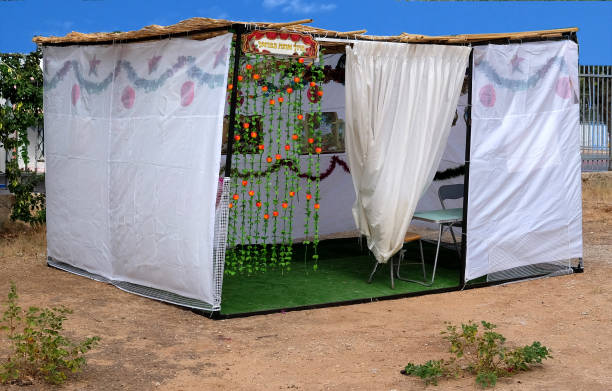 a sukkah or succah is a temporary hut constructed for use during the week-long jewish festival of sukkot. it is topped with branches and often well decorated with autumnal, harvest or judaic themes - themes imagens e fotografias de stock