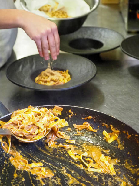 istock chef plating tagliatelle sauce pasta into black design dishes - mise en place 1431910804