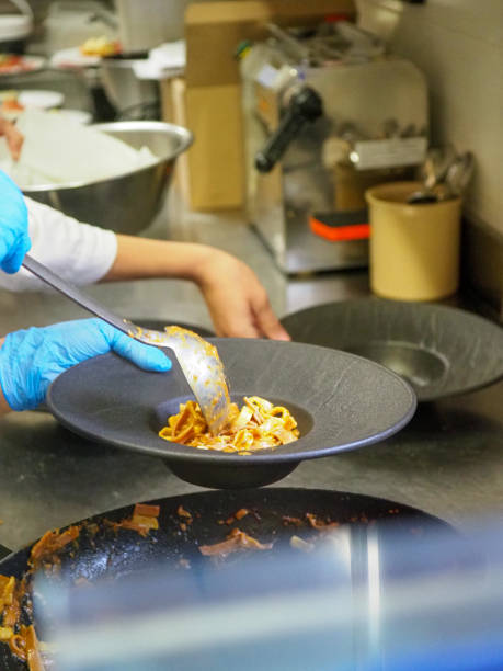 istock chef plating tagliatelle sauce pasta into black design dishes - mise en place 1431910805