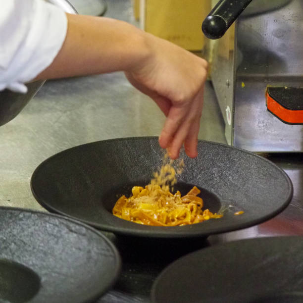 istock chef plating tagliatelle sauce pasta into rustic dishes pouring parmesan cheese 1431910814