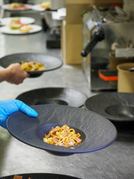 istock chef plating tagliatelle sauce pasta into black design dishes - mise en place 1431910832