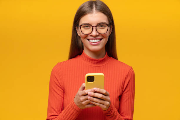istock Woman using phone reading and commenting posts on social media isolated on yellow background 1431911006