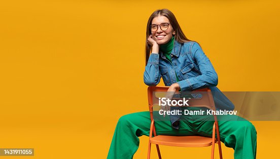 istock Banner of woman sitting on chair with dreamy pensive face, isolated on yellow background 1431911055