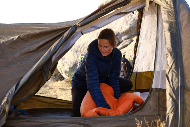 istock A woman compressing the sleeping bag in the tent. 1431912409